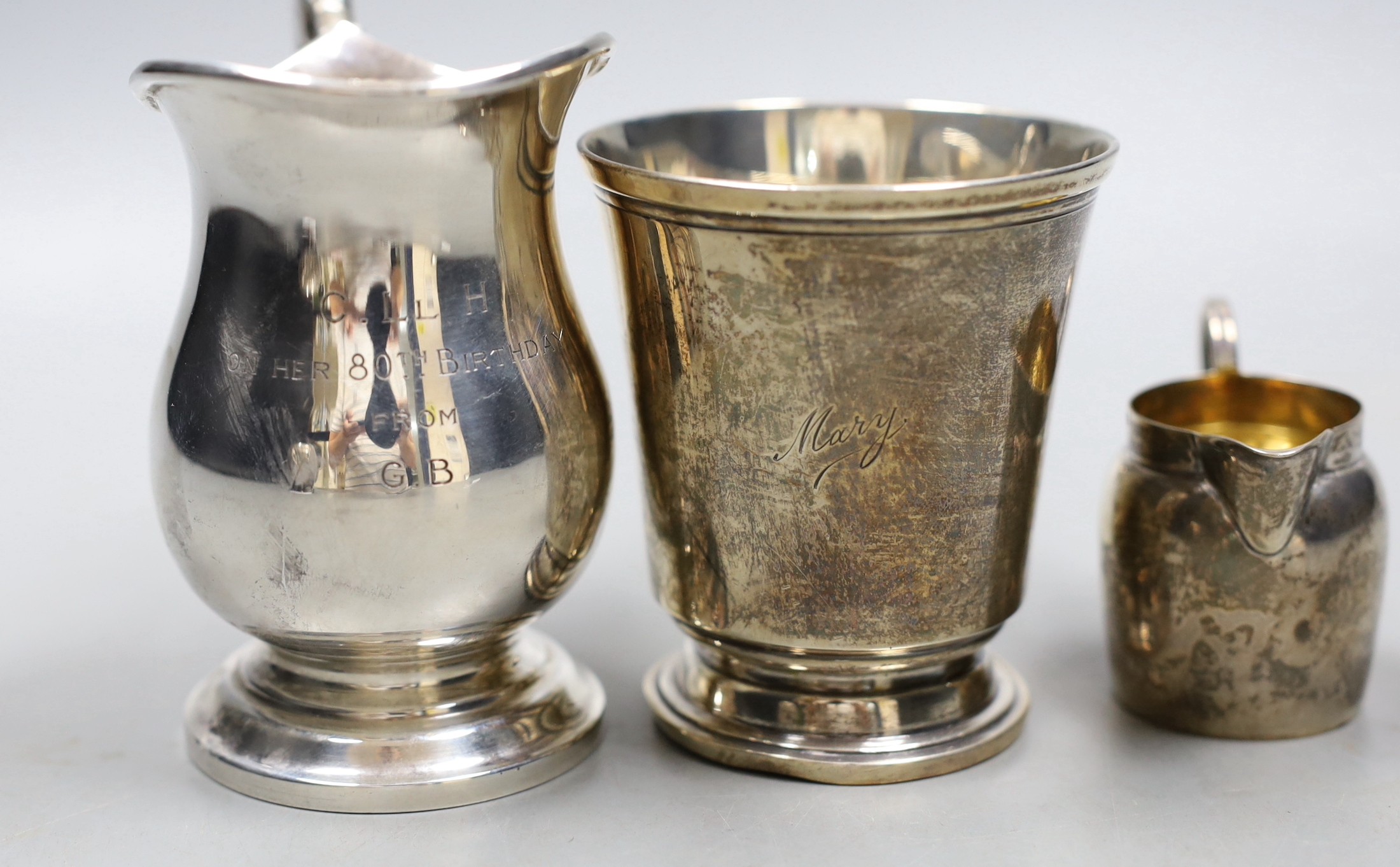 A 1960's silver cream jug, a small cream jug and a George V silver christening mug, 9.5 oz.